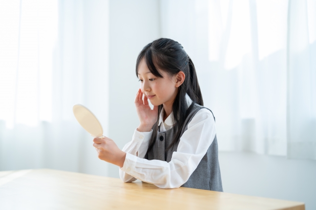 鏡を見つめる小学生